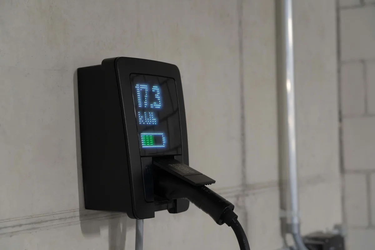 Wall-mounted home EV charger plugged in